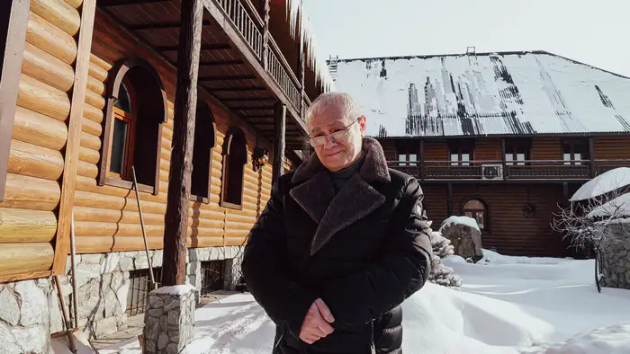 Юрий Костанянц на фоне своего дома-музея со скульптурами из дерева в Усть-Каменогорске